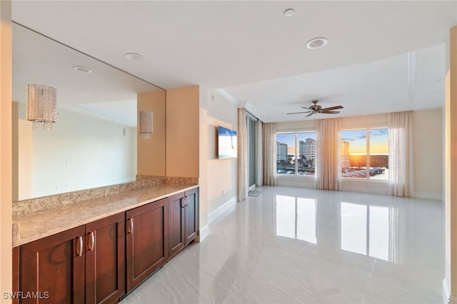 kitchen featuring light countertops, a ceiling fan, and baseboards