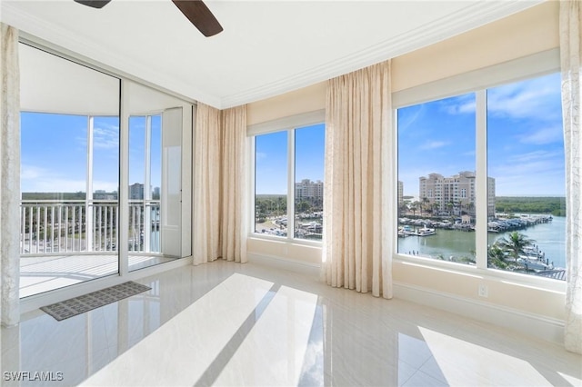 empty room featuring a city view, crown molding, a water view, a ceiling fan, and baseboards