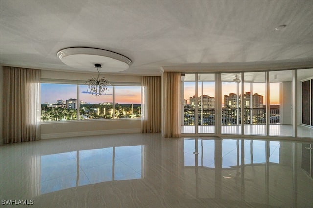 interior space featuring baseboards, a city view, tile patterned flooring, and an inviting chandelier