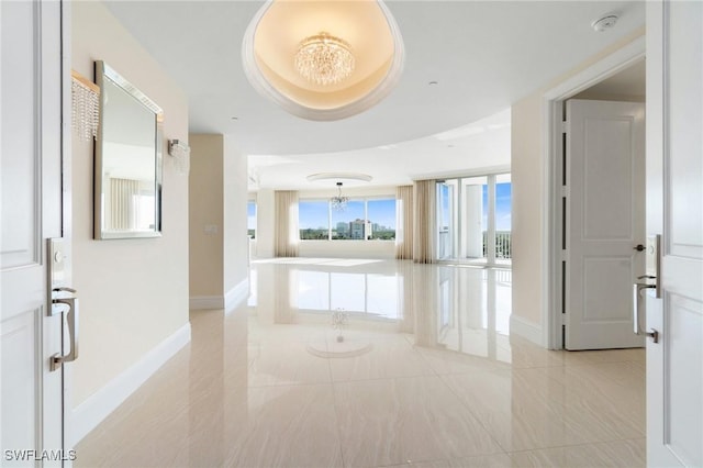 hallway featuring marble finish floor and baseboards