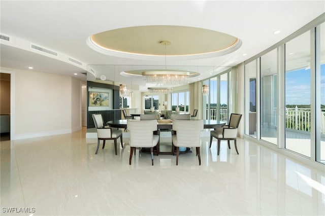 dining room featuring a raised ceiling, visible vents, and baseboards