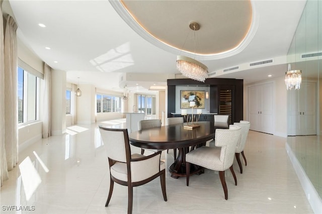 dining area featuring a tray ceiling, visible vents, and a notable chandelier