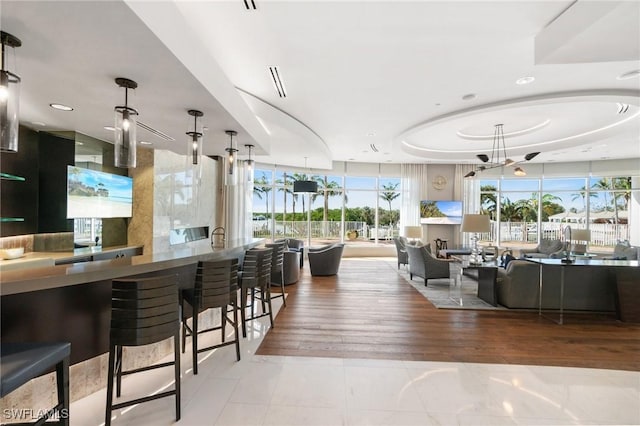 bar featuring floor to ceiling windows, a raised ceiling, wood finished floors, and recessed lighting