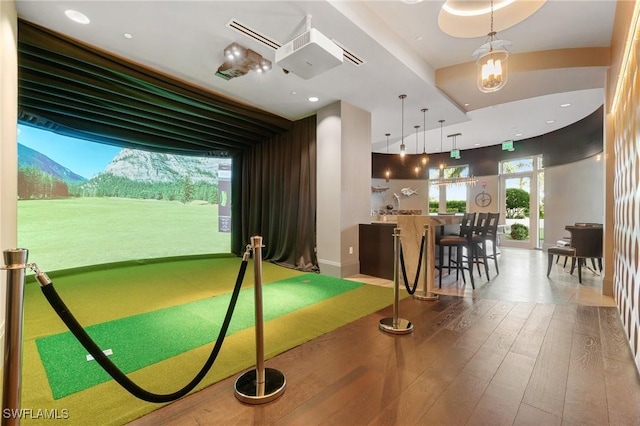 game room with golf simulator and hardwood / wood-style floors