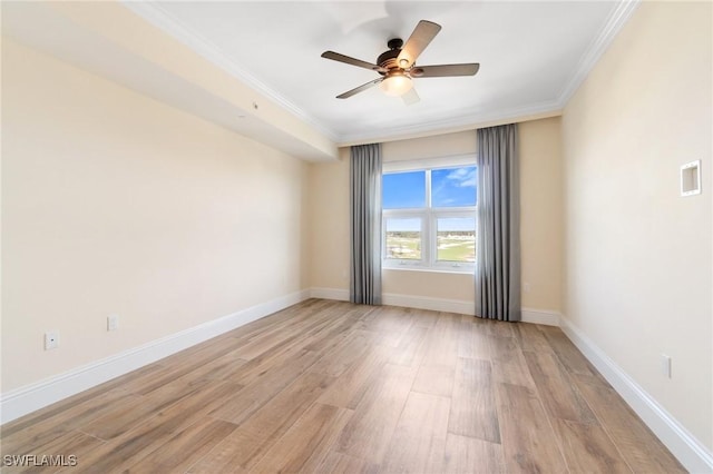 spare room with a ceiling fan, baseboards, crown molding, and light wood finished floors