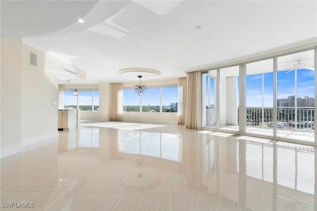 empty room featuring a chandelier, visible vents, baseboards, floor to ceiling windows, and crown molding