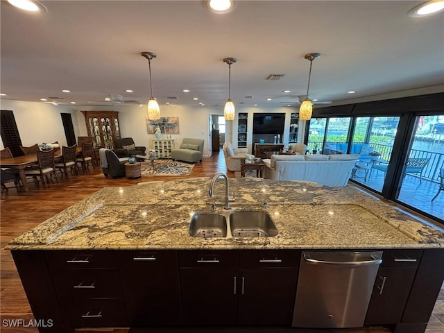 kitchen with dishwasher, light stone countertops, sink, and dark brown cabinetry