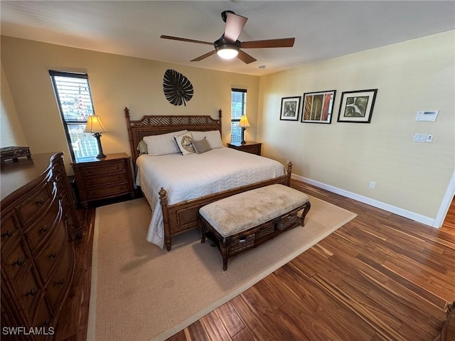 bedroom with ceiling fan, wood-type flooring, and multiple windows