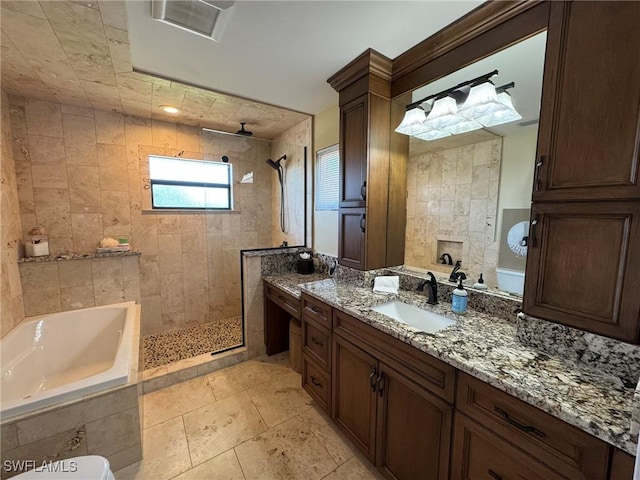 bathroom with ceiling fan, vanity, and independent shower and bath