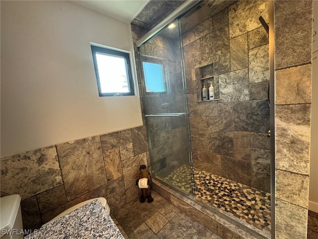 bathroom featuring toilet, tile walls, and walk in shower