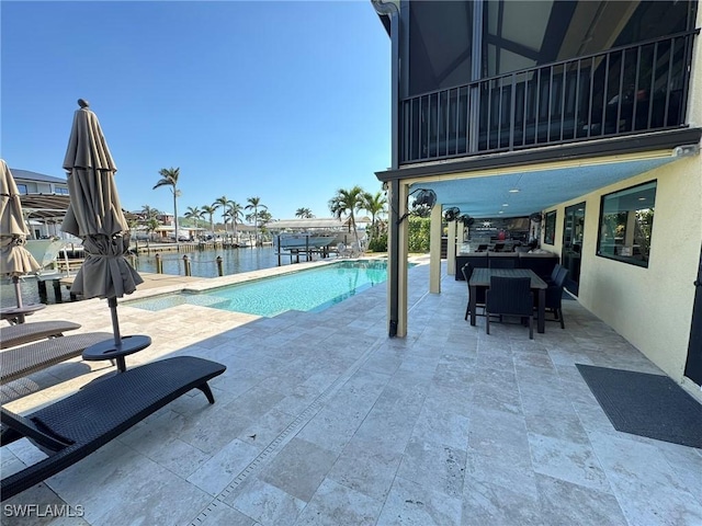 view of swimming pool featuring a patio and a water view