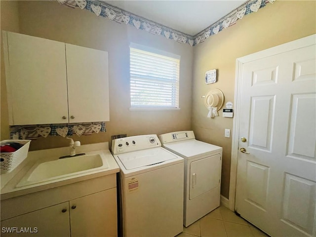 clothes washing area with cabinets, sink, light tile patterned floors, and independent washer and dryer