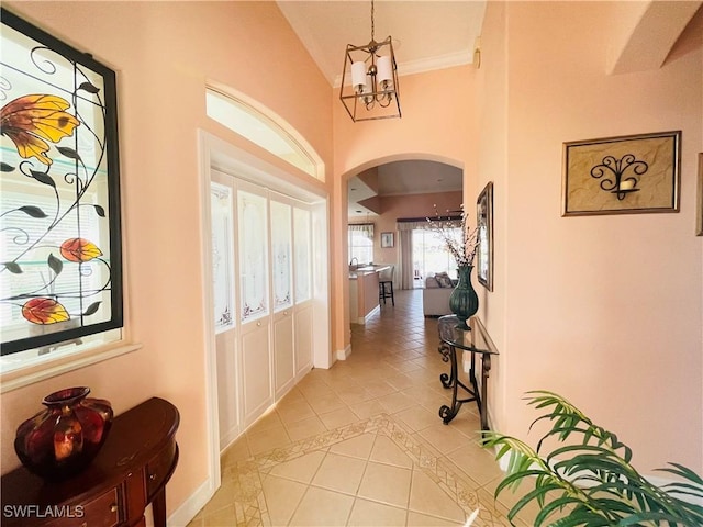 corridor with an inviting chandelier and light tile patterned flooring