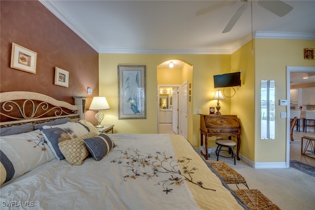 carpeted bedroom with arched walkways, ornamental molding, ensuite bath, and baseboards