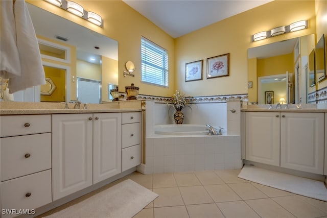 bathroom with a garden tub, tile patterned flooring, a sink, two vanities, and visible vents