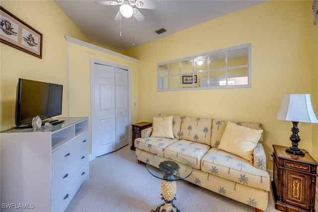 living area featuring light carpet, visible vents, and a ceiling fan