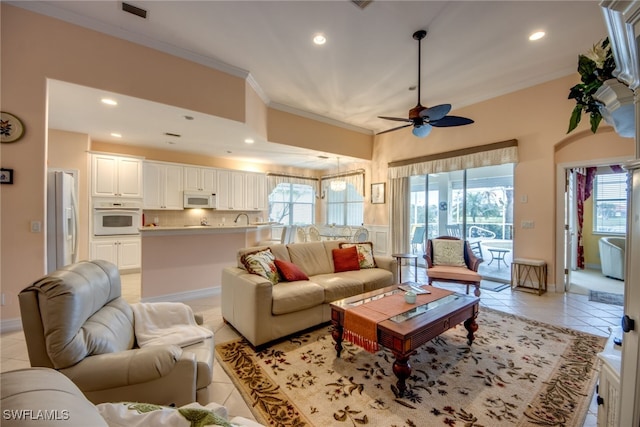 living area with light tile patterned floors, ceiling fan, recessed lighting, baseboards, and crown molding