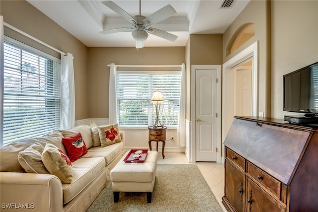 living room featuring light tile patterned floors, plenty of natural light, visible vents, and a tray ceiling