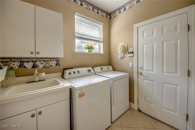 washroom featuring a sink, cabinet space, washer and dryer, and light tile patterned flooring