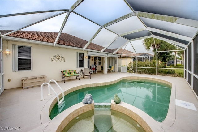 view of pool featuring a lanai, a patio area, and a pool with connected hot tub