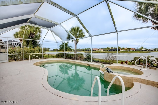 view of pool featuring a patio area, glass enclosure, a water view, and a pool with connected hot tub