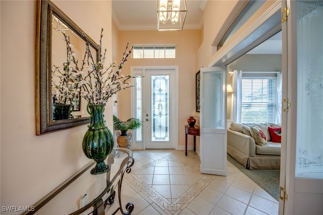 foyer entrance with ornamental molding, an inviting chandelier, baseboards, and light tile patterned floors