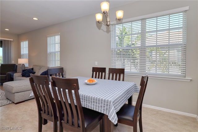 tiled dining room featuring a notable chandelier