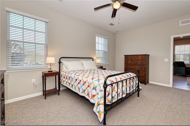 carpeted bedroom with multiple windows and ceiling fan