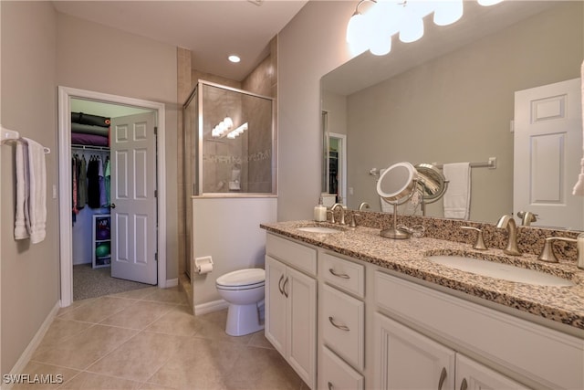 bathroom featuring tile patterned flooring, vanity, an enclosed shower, and toilet