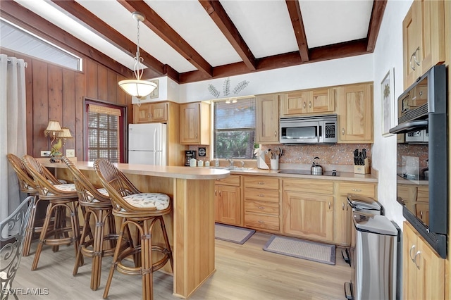 kitchen with backsplash, a kitchen breakfast bar, light brown cabinetry, decorative light fixtures, and white fridge