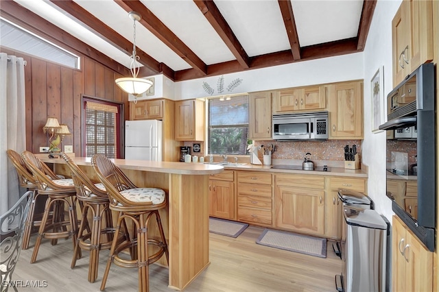 5370/5372 Palmetto St, Fort Myers Beach, FL 33931 - kitchen with light countertops, freestanding refrigerator, tasteful backsplash, a kitchen breakfast bar, and stainless steel microwave