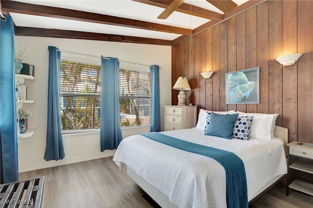 bedroom with dark wood-type flooring, ceiling fan, wooden walls, and lofted ceiling with beams