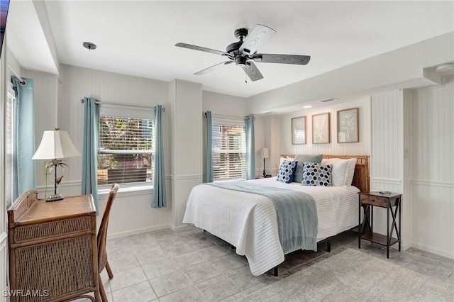 tiled bedroom with ceiling fan and multiple windows