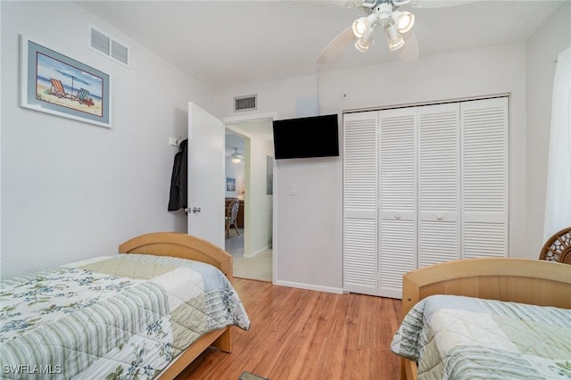 bedroom featuring ceiling fan, light hardwood / wood-style floors, and a closet