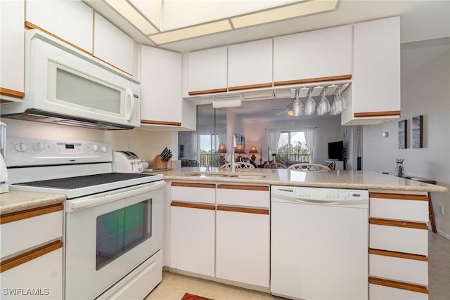 kitchen with white cabinetry, white appliances, and kitchen peninsula