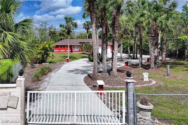 exterior space featuring a fenced front yard, a gate, and driveway