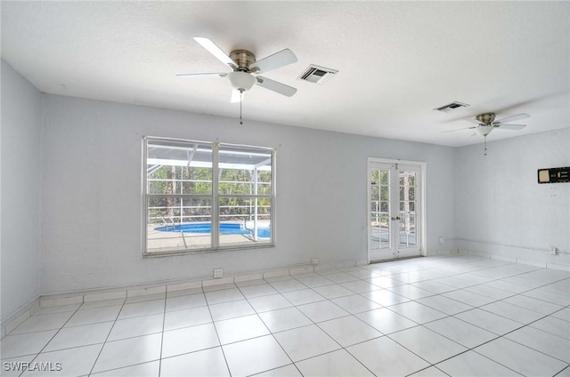 spare room featuring french doors, visible vents, ceiling fan, and light tile patterned floors