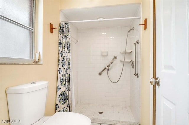 bathroom featuring toilet and a shower stall