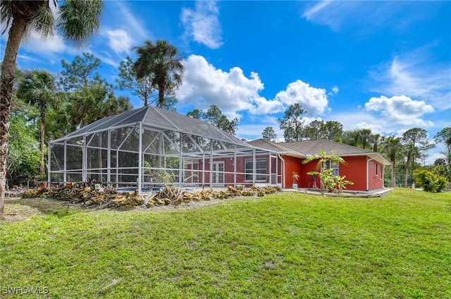 rear view of property with glass enclosure and a yard