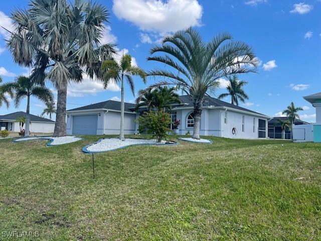 ranch-style home with a garage and a front lawn