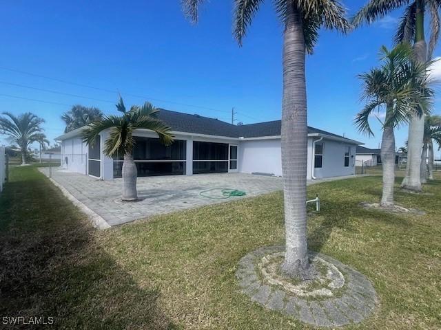 rear view of property with a sunroom, a yard, and fence