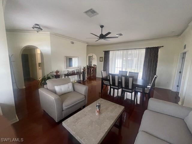 living room with crown molding, dark hardwood / wood-style flooring, and ceiling fan