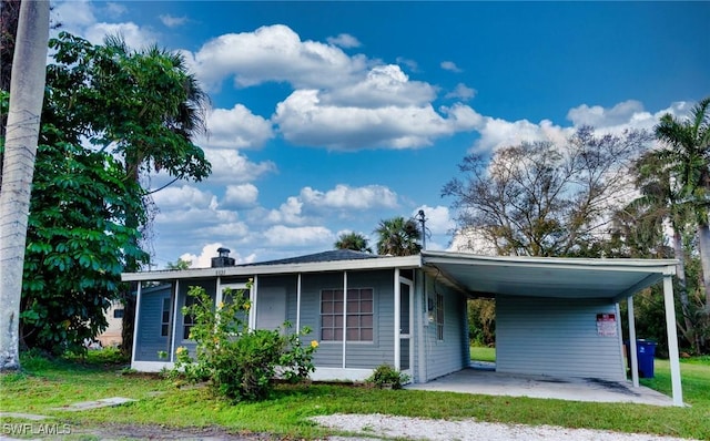 view of front of home with a carport and a front yard