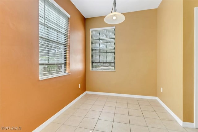 spare room featuring light tile patterned floors and baseboards