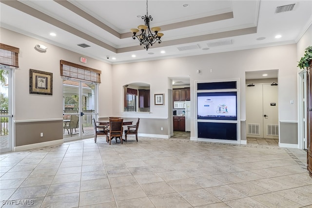 living room featuring crown molding, a towering ceiling, light tile patterned flooring, and a tray ceiling