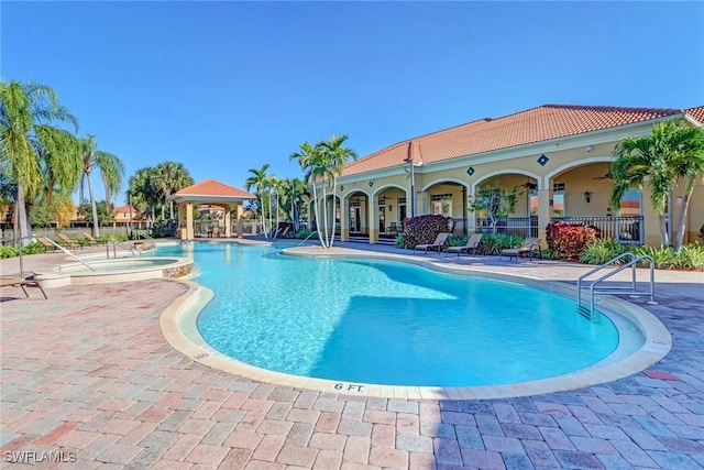 view of swimming pool with a gazebo, a hot tub, and a patio area