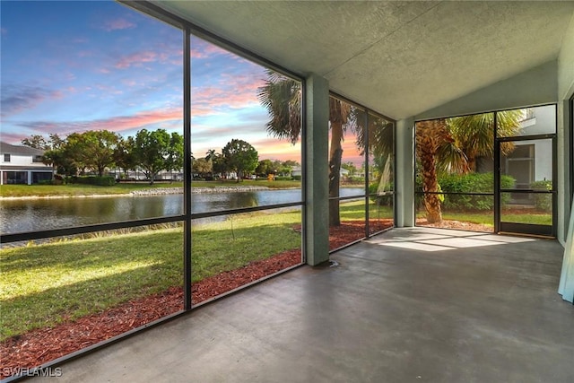 unfurnished sunroom featuring lofted ceiling and a water view