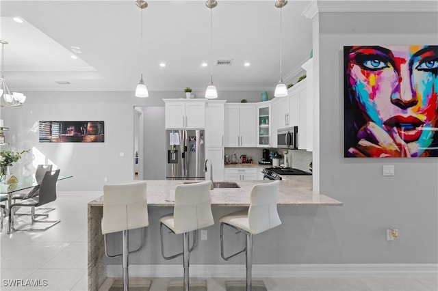 kitchen featuring pendant lighting, sink, crown molding, stainless steel appliances, and white cabinets