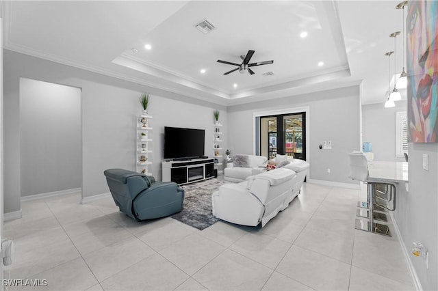 living room featuring crown molding, ceiling fan, and a raised ceiling