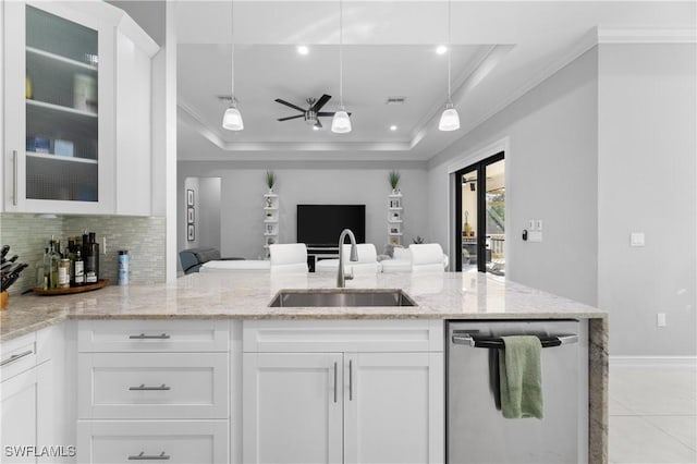 kitchen featuring dishwasher, sink, white cabinets, a raised ceiling, and light stone countertops